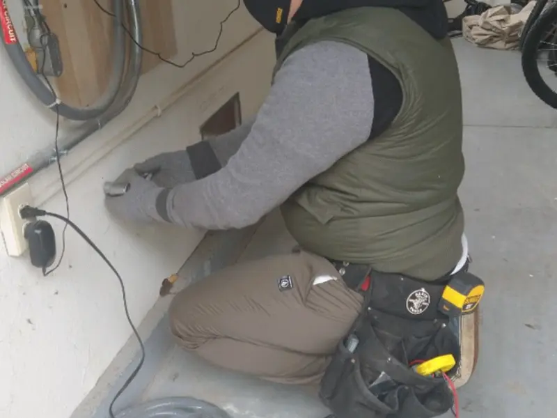 Electrician performing outlet wiring in a Granite Hills garage